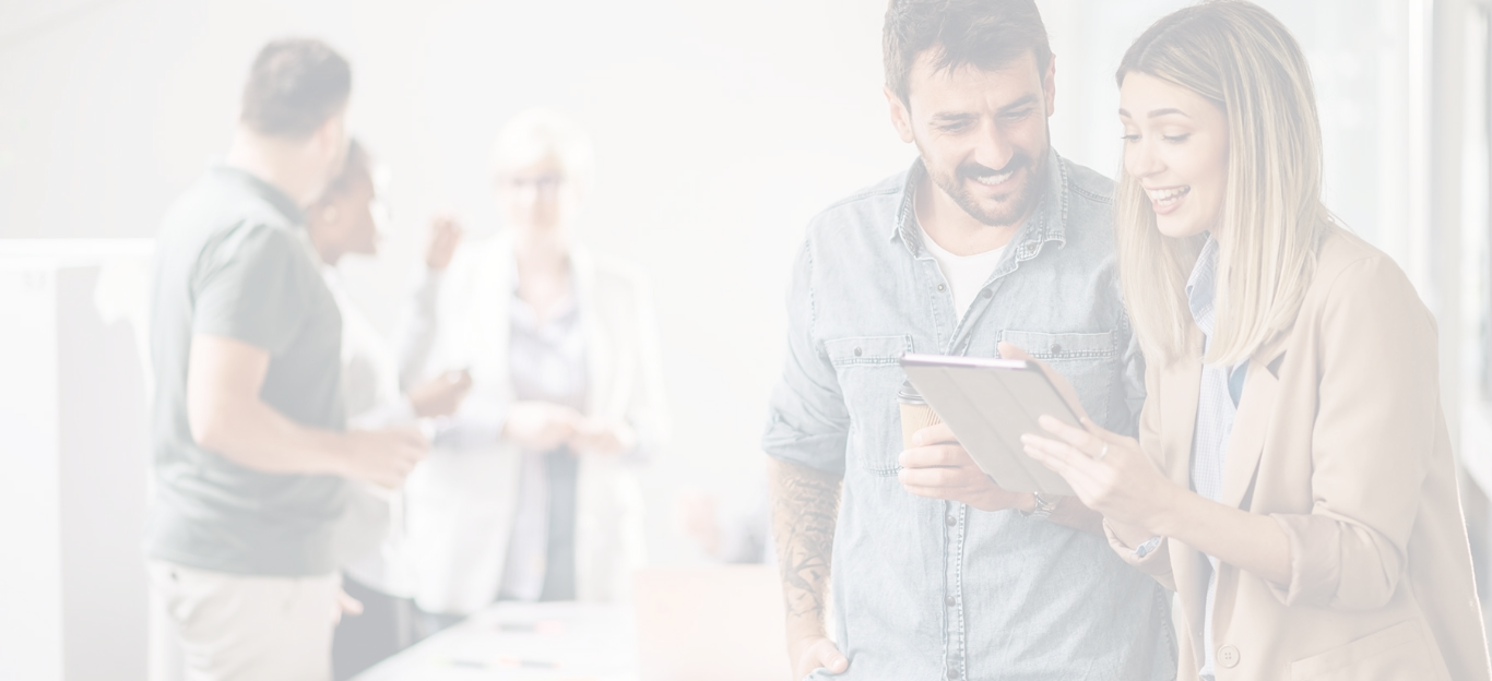 Profesionales revisando información en una tablet con equipo trabajando al fondo.